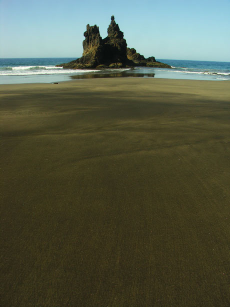 Fels in der mitte eines schwarzen sandstrand bei anaga norden teneriffa foto