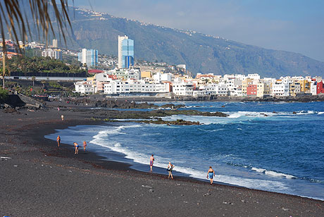 Schwarze sandstrand in der naehe von touristischen orte auf teneriffa foto