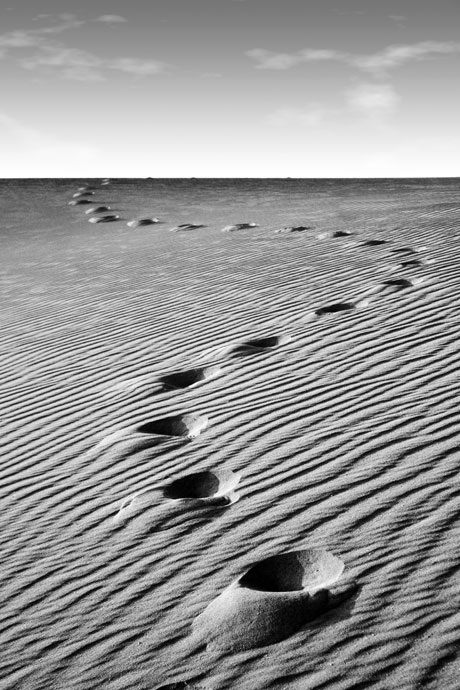 Foot steps on rippled sand photo