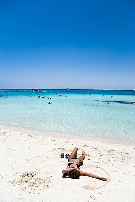 Girl soaking up the sun on the white sand beach in Tenerife photo